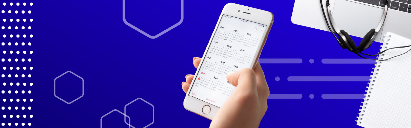 A hand holds a cellphone calendar on an aesthetic background alongside a laptop, notebook, and headphones.