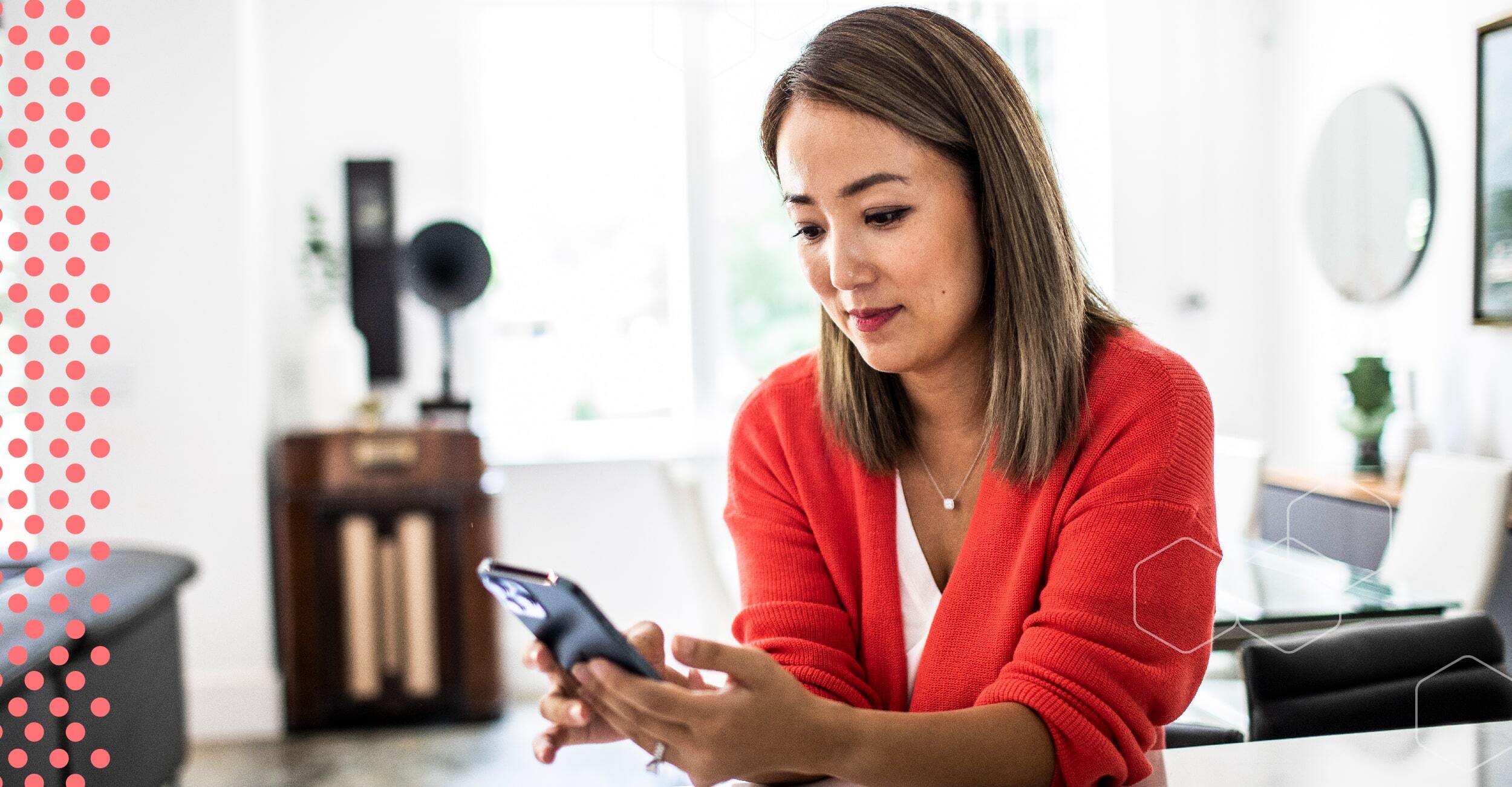 A business woman looks at her phone in an office.