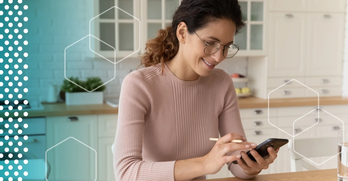 Woman holds a stylus as she looks at her phone