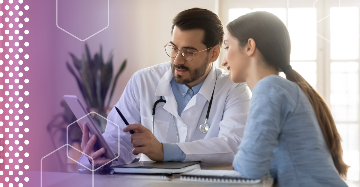 A young doctor speaks with a patient while holding a tablet.